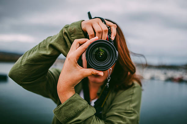 a young woman using a dslr camera